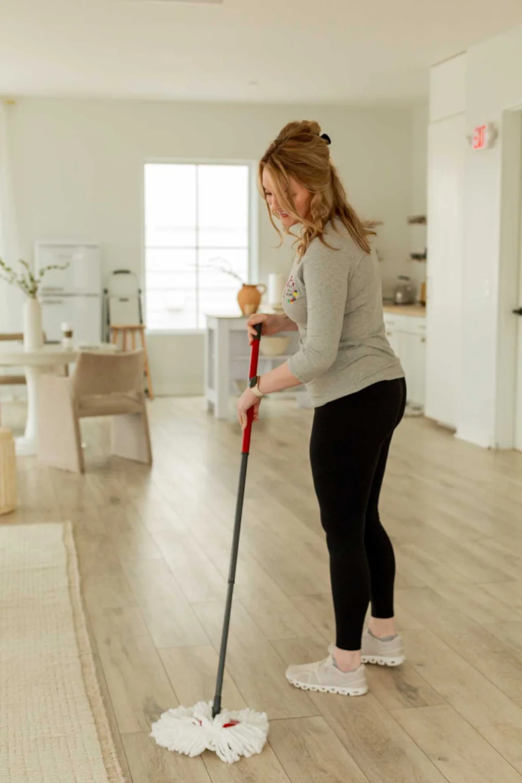 A Time To Take A Load Off cleaner smiling while working in a home