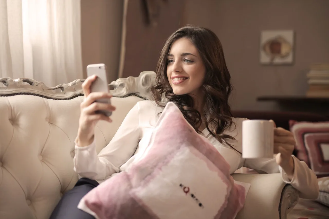 A woman relaxing with a mug in a bright, clean living room